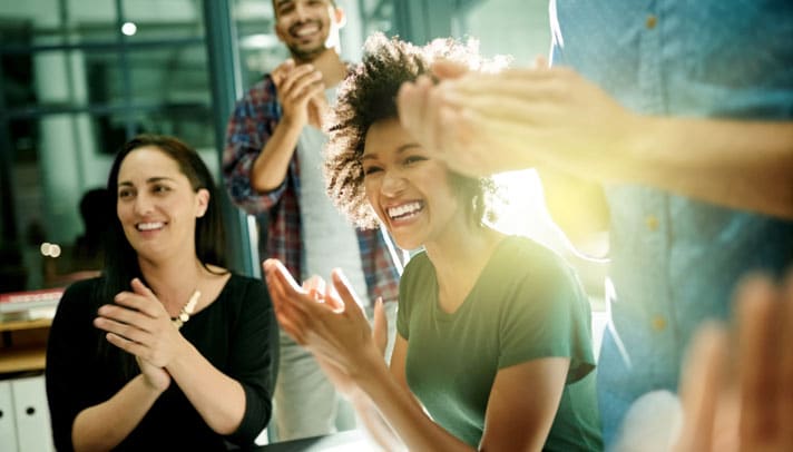 diverse employees clap at a presentation