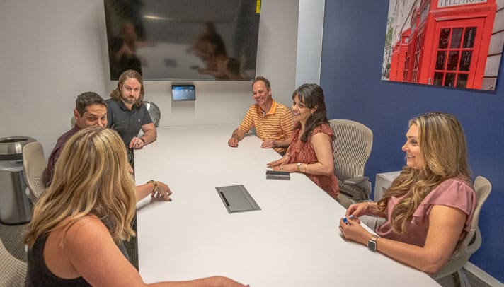 employees engage in a team meeting in the conference room